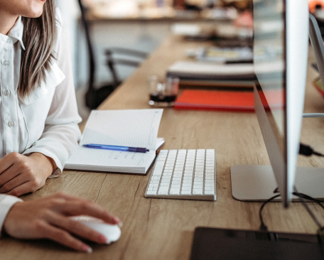 a professional woman working in front of a computer at the desk